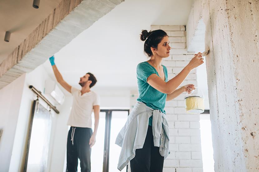 man and woman painting a room in a house
